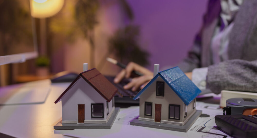 an experienced female engineer is giving a final check to a house model in her private office to make sure it meets the blueprints and meets the construction deadline